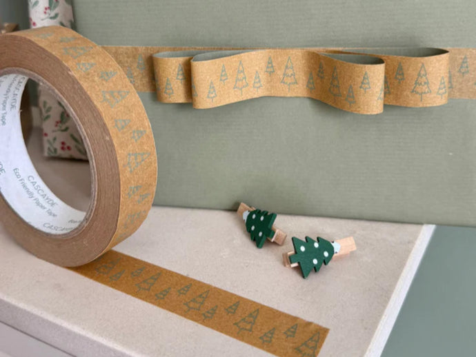 Roll of decorative tape with Christmas tree pattern on a green surface